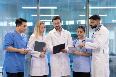 Doktorlar ve hemşireler, takım çalışmalarını ve profesyonel bakımı vurgulayarak, modern bir tıbbi ortamda işbirliği yaparlar..