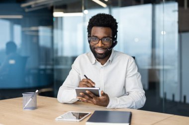 Modern bir ofiste kendine güvenen bir profesyonel, dijital araçları kullanırken sanal danışmanlık oturumuna katılıyor, üretkenliğe olan bağlılığını gösteriyor