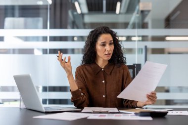 Kafası karışmış bir iş adamı, ofis ortamında masa başında çalışırken işyerindeki zorlukları yansıtan bir belge tutuyor. Sahne, iş ve problem çözme temalarını aktarıyor