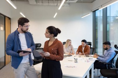 Çeşitli takım üyeleriyle birlikte dizüstü bilgisayarlar, tabletler ve belgeler kullanarak ofis kurmak. İşbirliği ve sinerji üretken ve dinamik bir mesleki ortamı yansıtır
