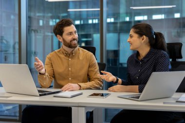 Modern bir çalışma ortamında iki iş arkadaşı arasındaki profesyonel işbirliği.