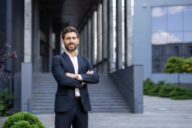 Çağdaş ofis ortamının dışında güvenle poz veren profesyonel bir birey, başarıyı ve liderliği simgeliyor..