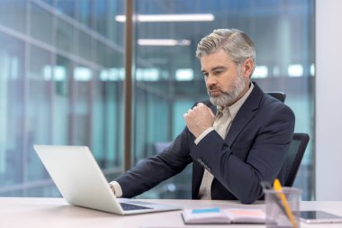 Günümüz kurumsal ortamında dizüstü bilgisayar kullanan profesyonel iş adamları üretkenliği sembolize ediyor..
