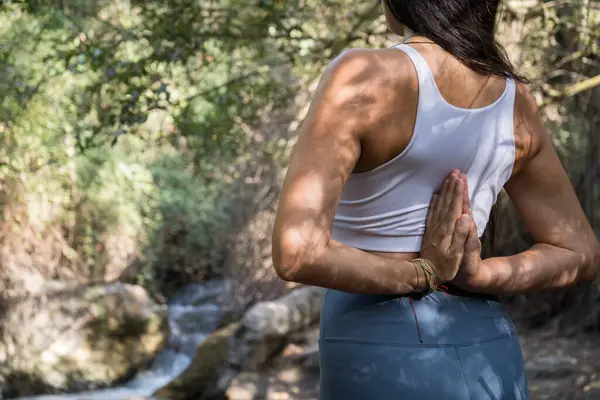 Nehirde yoga yapan kadın.
