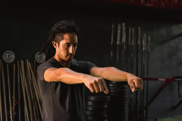 Spor salonunda gerinen bir adam var.