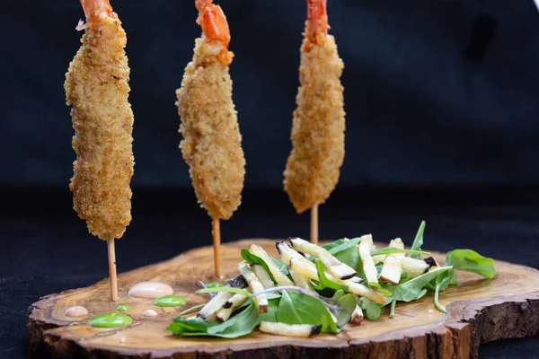pinchos de langostinos empanados fritos con hojas verdes, plato tipico de la comida peruana