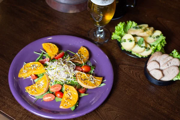 Plato de Vejetaryenler Grillados con ensalada acompaado por cerveza