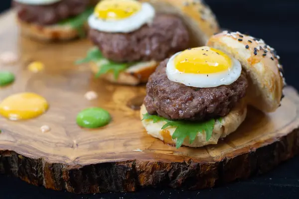 Mini hamburgerler con huevo fritos y salsas in sandwich
