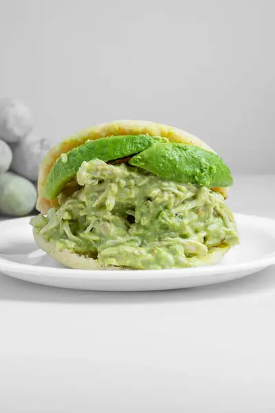 Avokado ve peynirle doldurulmuş vegan arepa.