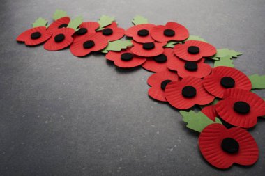 Dünya Savaşı 'nı anma günü. Koyu taşlı arka planda kırmızı kağıt gelincikleri.