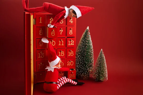 Boże Narodzenie Kalendarz Adwentowy Elfem Prezenty Czerwonym Tle — Zdjęcie stockowe