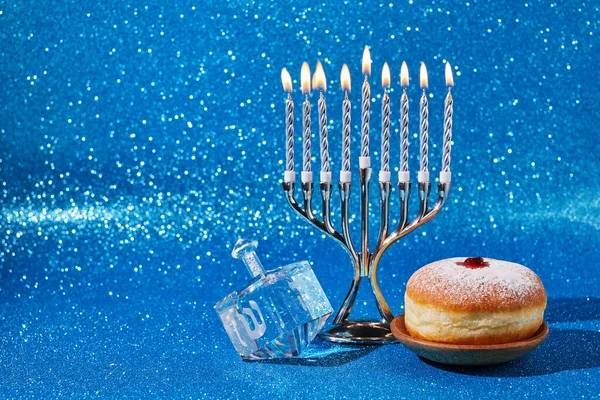Jewish holiday Hanukkah background with menorah and dreidel with letters Gimel and Nun