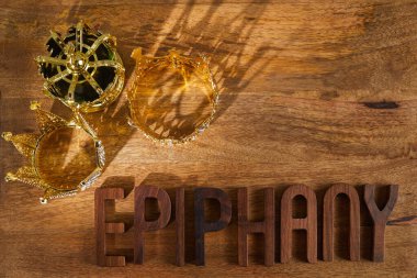 Happy Epiphany day. Three gold crowns on wooden background, symbol of Tres Reyes Magos, Three Wise Men. . High quality photo