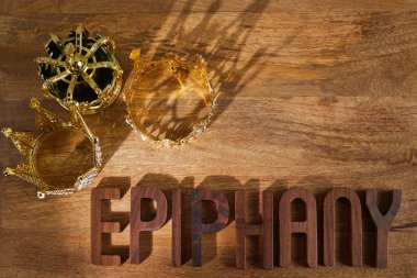 Happy Epiphany day. Three gold crowns on wooden background, symbol of Tres Reyes Magos, Three Wise Men. . High quality photo