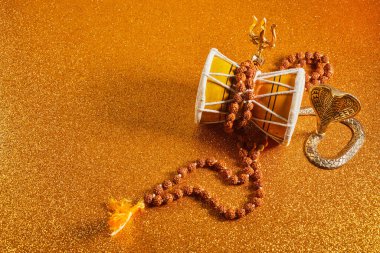 Shivaratri background with Shivas trident and Pellet Drum Damroo musical instrument . Hindu festival Maha Shivratri. High quality photo