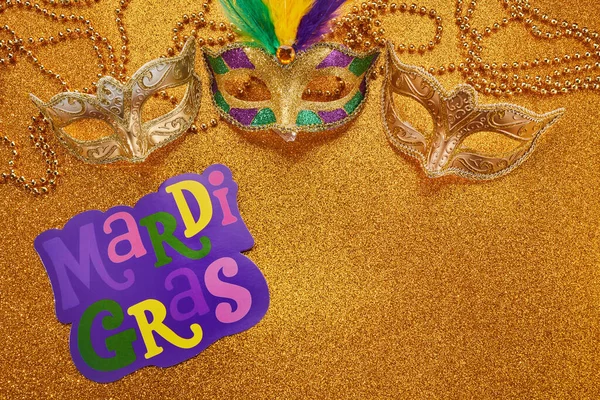 Mardi gras or carnival mask with beads on gold glowing background. Venetian mask. High quality photo