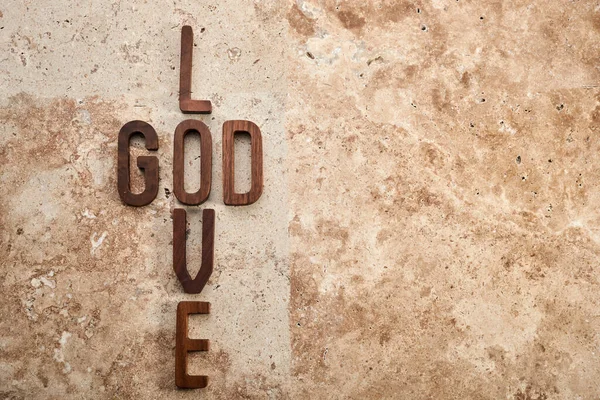 God is love concept text lying on the rustic travertine stone background