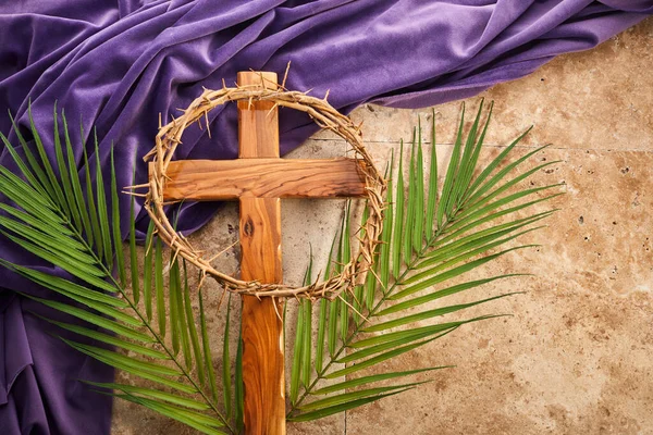 Lent season, Holy week and Good friday concept. Palm leave and cross on stone background.