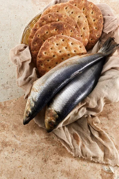 Catholic still life of five loaves of bread and two fish.