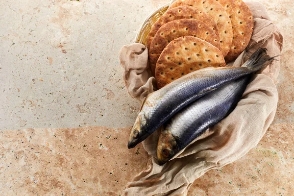 Catholic still life of five loaves of bread and two fish.