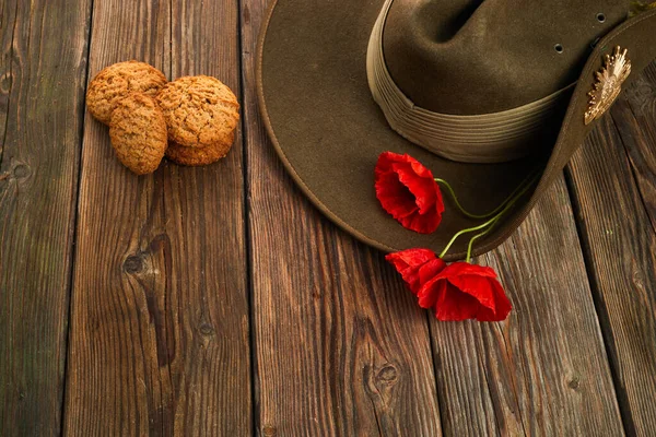 澳大利亚Anzac日 澳大利亚军队的草帽红罂粟和木制背景的传统安扎克饼干 — 图库照片