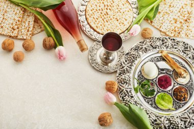 Passover Seder plate with traditional food, walnuts, matza and wine on grunge background. clipart