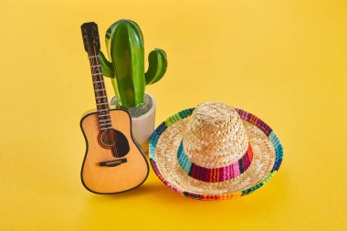 Cinco de Mayo tatil geçmişi. Kaktüs, gitar ve sarı arka planda şapka.