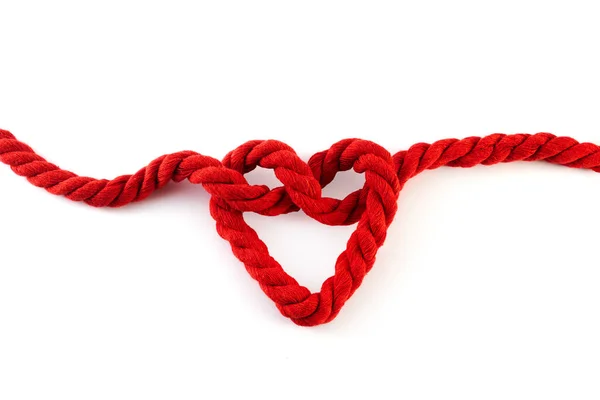 白い背景にハート型の結び目が孤立した赤いロープ — ストック写真