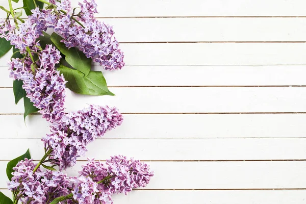 白い木の背景にライラックの花とフレーム トップビュー フラットレイアウト — ストック写真