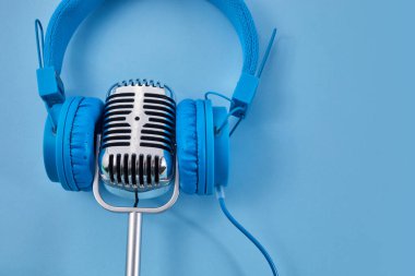 Dünya müzik günü konsepti. Müzik kulaklığı ve mavi arka planda bir mikrofon..