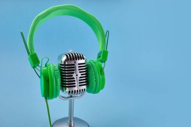 Dünya müzik günü konsepti. Müzik kulaklığı ve mavi arka planda bir mikrofon..