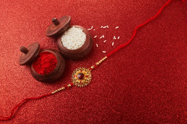 Raksha Bandhan Rakhi Schnur Reiskörner Und Kumkum Auf Rotem Hintergrund — Stockfoto