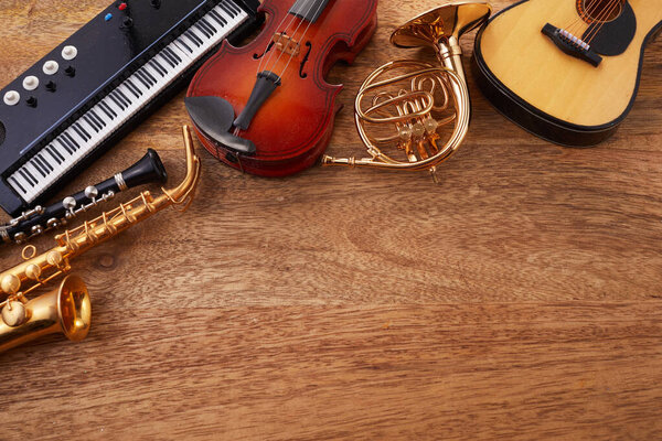 Frame of different musical instruments on wooden background.