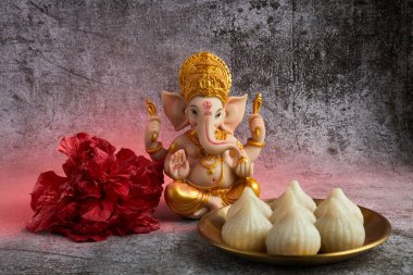 Idol of lord Ganesha with Modak Sweet Dish and flower. Ganesh chaturthi.