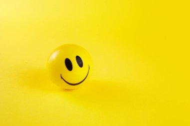 Dünya gülme günü, sarı arka planda gülen surat topu..