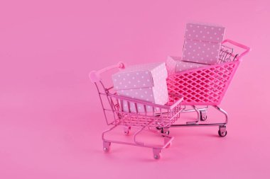 Pembe Cuma konsepti. İnternetten alışveriş arabası ve hediyeler.