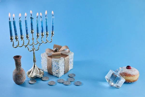 Jewish holiday Hanukkah with menorah, traditional Candelabra, donut and dreidel, spinning top