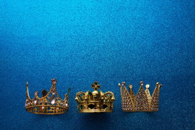 Epiphany Günü ya da Dia de Reyes Magos konsepti. Mavi parlak arka planda üç altın kaplama.
