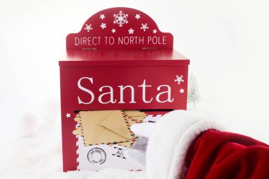 Noel Baba mektup dolu posta kutusunu açıyor.