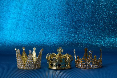 Epiphany Günü ya da Dia de Reyes Magos konsepti. Mavi parlak arka planda üç altın kaplama.