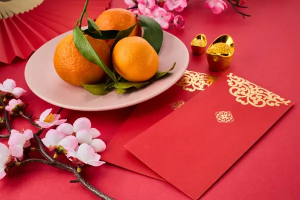Chinese New Year. Red packet envelope, flowers, mandarins, festival decorations on red background