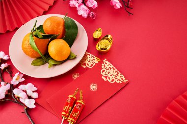 Çin Yeni Yılı. Kırmızı zarf, çiçekler, mandalina, kırmızı arka planda festival dekorasyonları