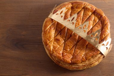 Tahta masanın üzerinde Epiphany pastası. Galette des Rois Fransa 'da geleneksel Epifani pastası.
