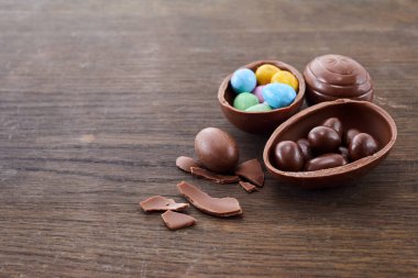Lezzetli çikolata Paskalya yumurtaları ve tatlılar ahşap arka plan üzerinde