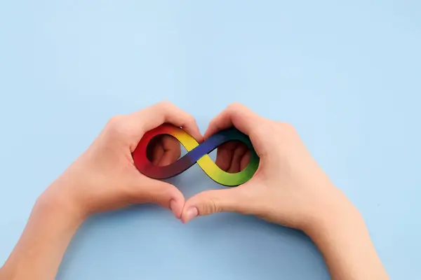 Autistische Jungenhände Und Regenbogen Acht Unendlichkeitssymbol Tag Des Autismus Bewusstseins lizenzfreie Stockbilder