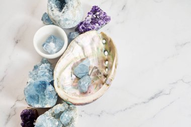 Mermer bir yüzeye dizilmiş çeşitli değerli taşlar ve kristaller..