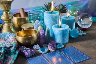 Mumlar, kristaller, tarot kartları ve Tibet şarkı kaseleriyle dolu sakin bir ortam..