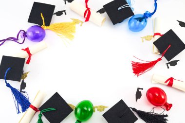Mezuniyet şapkaları, diplomalar ve beyaz üzerine renkli balonlar..