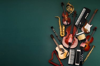 Koyu yeşil arka planda çeşitli müzik aletleri koleksiyonu
