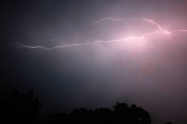 Gece gökyüzünde çarpıcı yıldırımlarla çarpan çarpıcı bir yıldırım..
